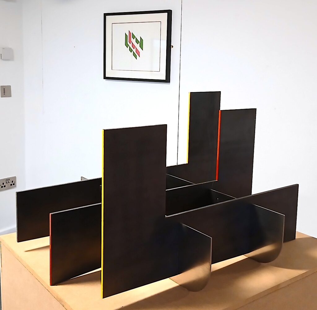 a geometric sculpture and wall image in an exhibition